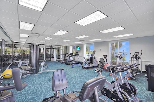 exercise room with carpet floors and a paneled ceiling