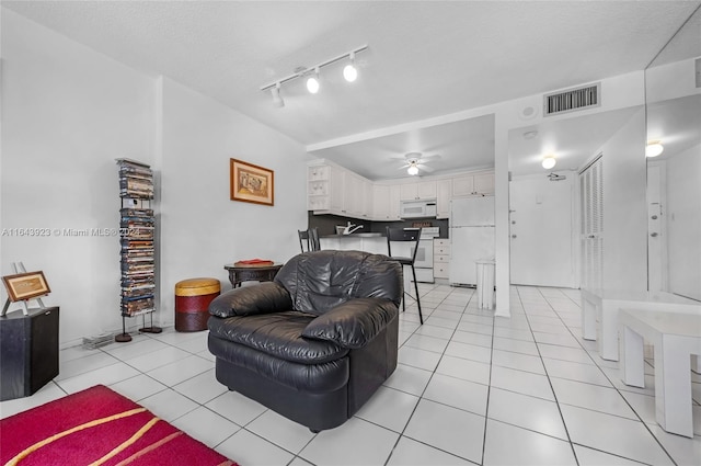 living room featuring a textured ceiling, ceiling fan, light tile patterned floors, and rail lighting