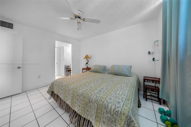 tiled bedroom featuring ceiling fan and a textured ceiling