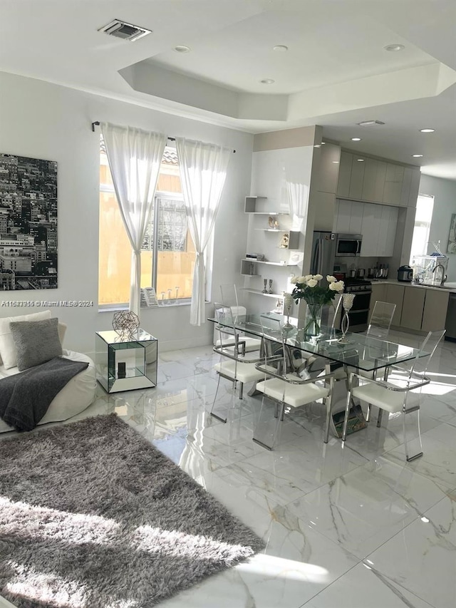 living room featuring light tile patterned floors and a tray ceiling