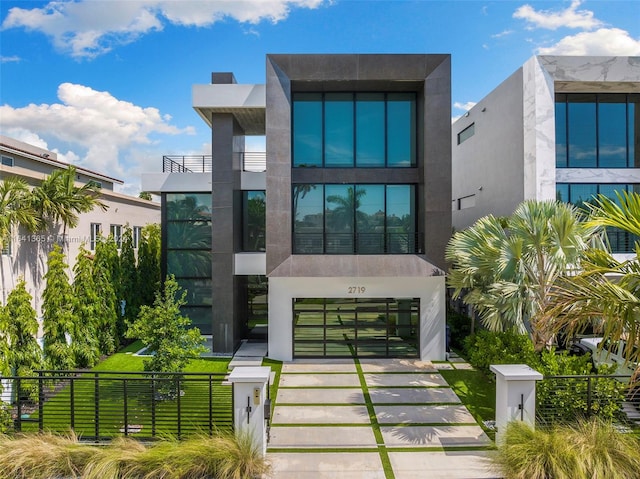 rear view of property with a balcony and a lawn