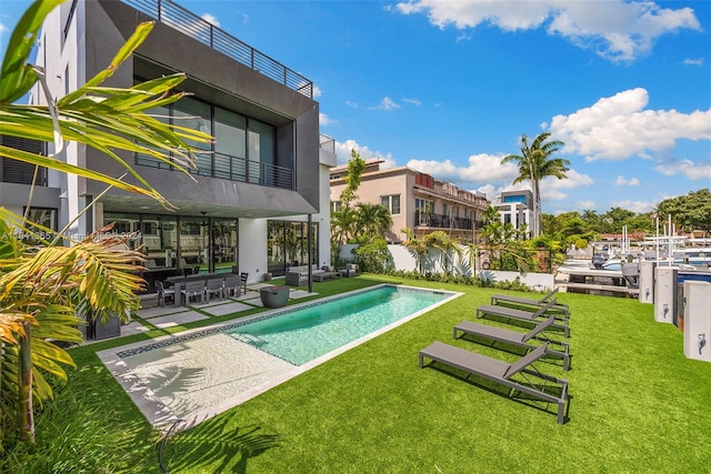 view of swimming pool featuring a lawn and a patio area