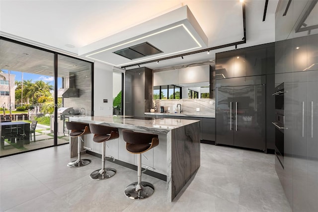 kitchen featuring light tile patterned floors, tasteful backsplash, stainless steel appliances, and light stone counters