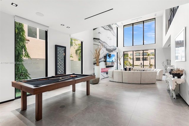 rec room featuring billiards, a high ceiling, light tile patterned floors, and a wealth of natural light