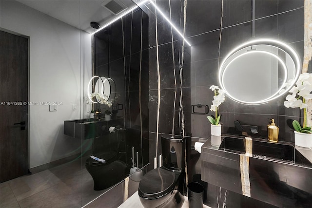 bathroom featuring tile walls, toilet, and tile patterned floors