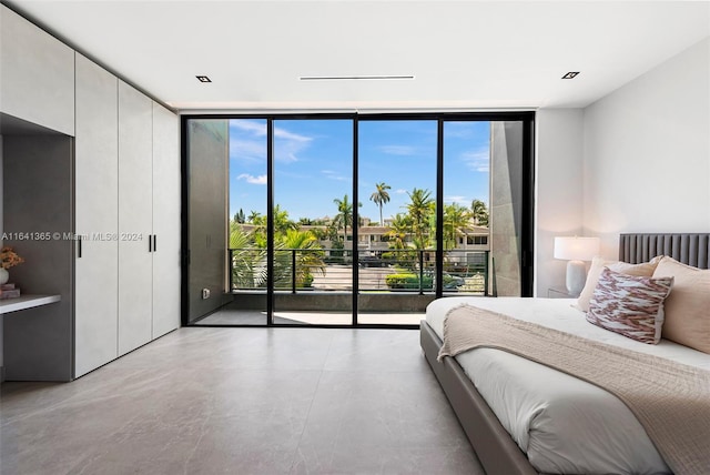 bedroom featuring multiple windows, access to outside, and a wall of windows