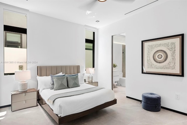 bedroom featuring light tile patterned floors, ceiling fan, and ensuite bath