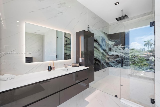 bathroom featuring a shower with shower door, tile patterned floors, vanity, and tile walls