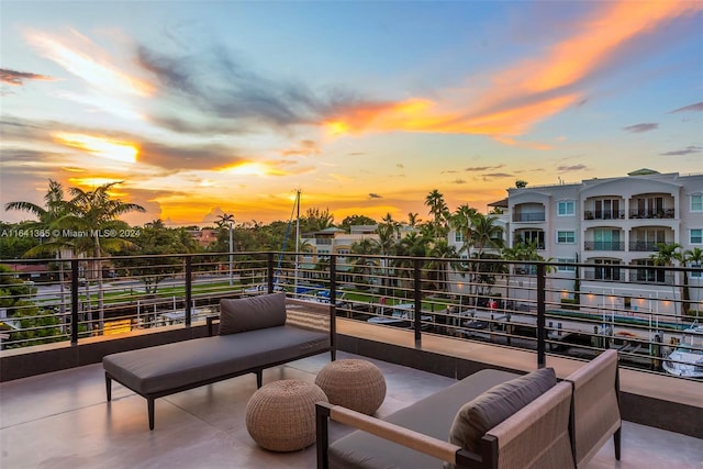 patio terrace at dusk featuring an outdoor hangout area and a balcony