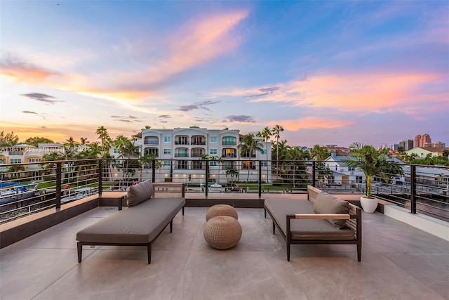 patio terrace at dusk featuring a balcony