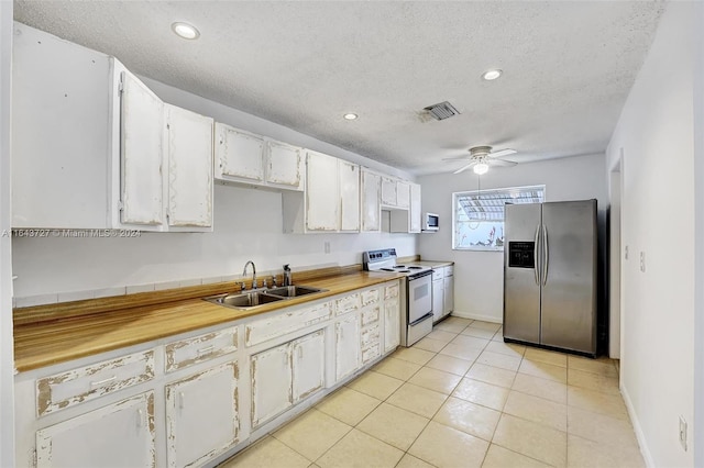 kitchen with white appliances, ceiling fan, white cabinetry, and sink