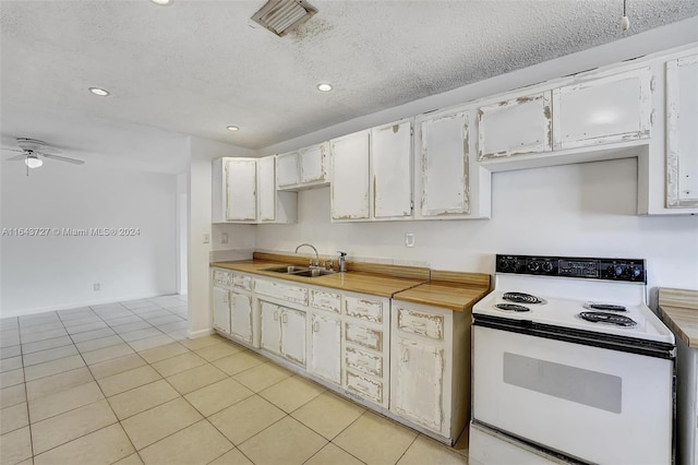 kitchen with light tile patterned floors, ceiling fan, sink, white range with electric stovetop, and white cabinets