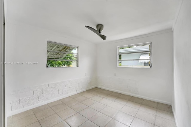 spare room with a wealth of natural light and light tile patterned flooring