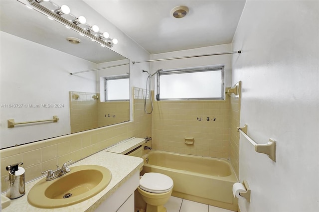 full bathroom with toilet, tile patterned floors, tiled shower / bath, vanity, and tasteful backsplash