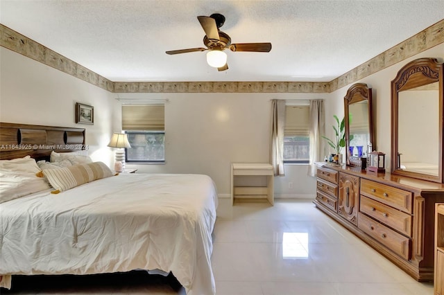 tiled bedroom with ceiling fan and a textured ceiling