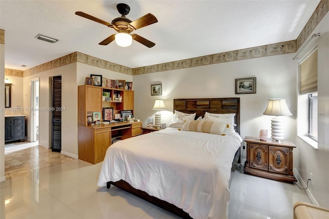 bedroom with a textured ceiling, ceiling fan, light tile patterned flooring, and ensuite bathroom