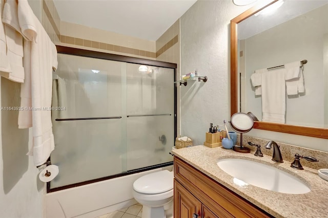 full bathroom featuring tile patterned floors, toilet, shower / bath combination with glass door, and vanity