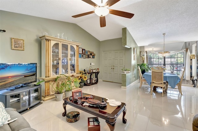 tiled living room with a textured ceiling, ceiling fan with notable chandelier, and lofted ceiling