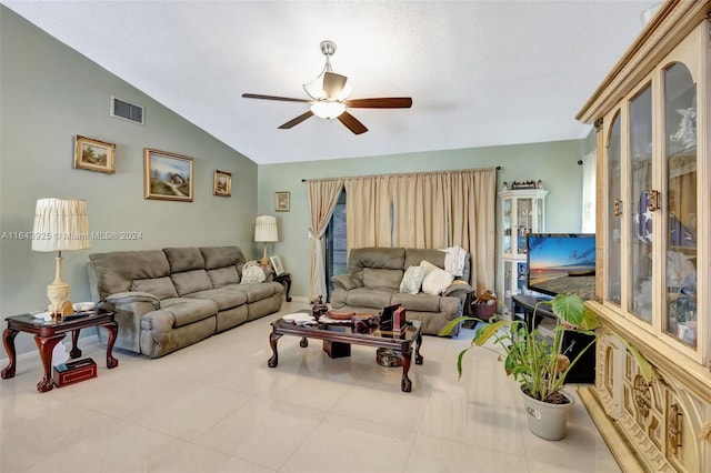 living room with ceiling fan, vaulted ceiling, and light tile patterned floors