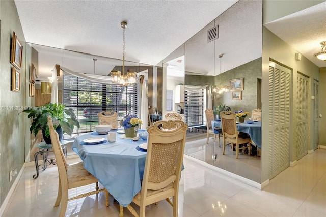 dining room with a textured ceiling, lofted ceiling, light tile patterned floors, and an inviting chandelier