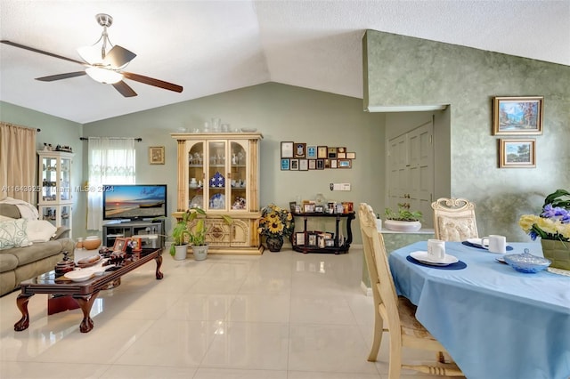 living room with ceiling fan, lofted ceiling, and light tile patterned floors