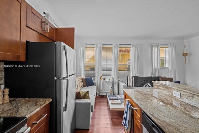 kitchen with dark wood-style floors, brown cabinets, ornamental molding, and light stone counters