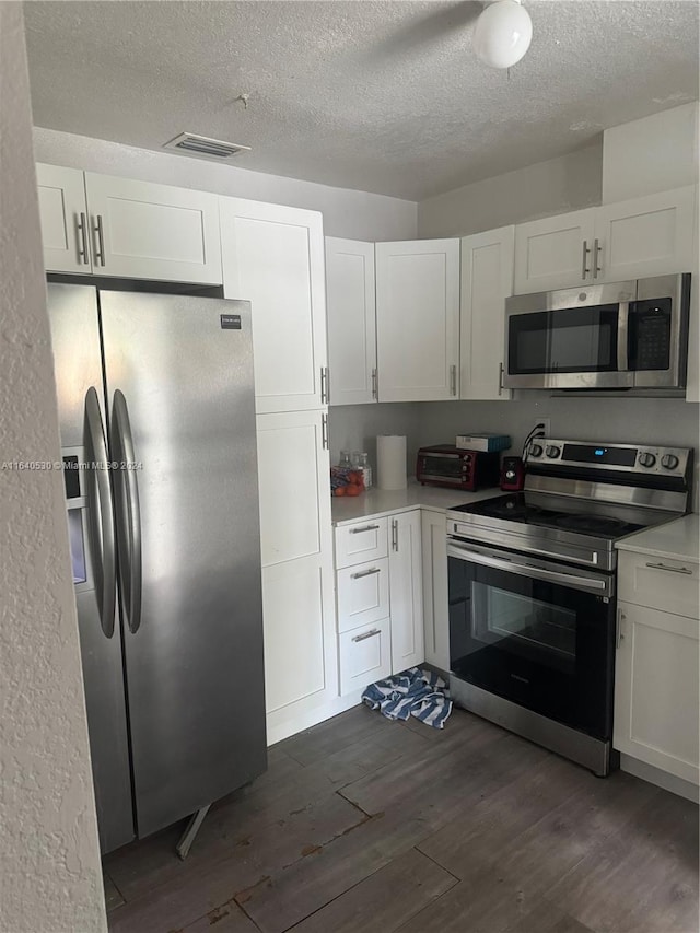 kitchen with dark hardwood / wood-style flooring, white cabinetry, and appliances with stainless steel finishes