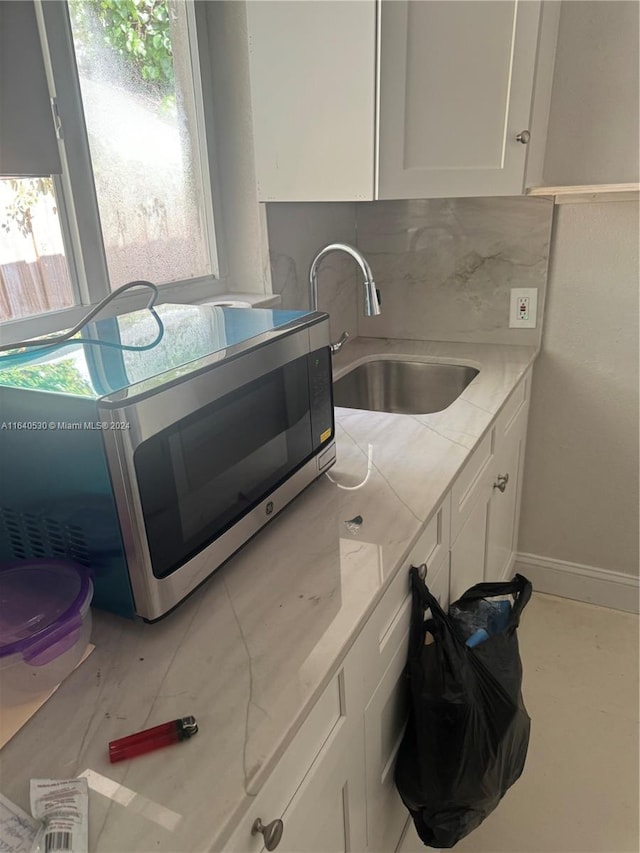 kitchen featuring backsplash, sink, and white cabinets