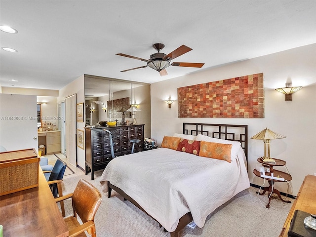 bedroom with ceiling fan, ensuite bathroom, and carpet