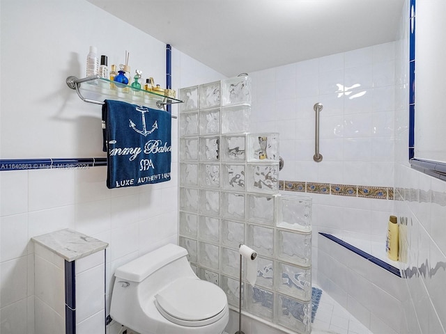 bathroom featuring tile walls, toilet, and a tile shower