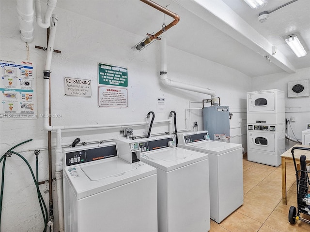 laundry room with washer and clothes dryer, water heater, stacked washer and clothes dryer, and light tile patterned floors