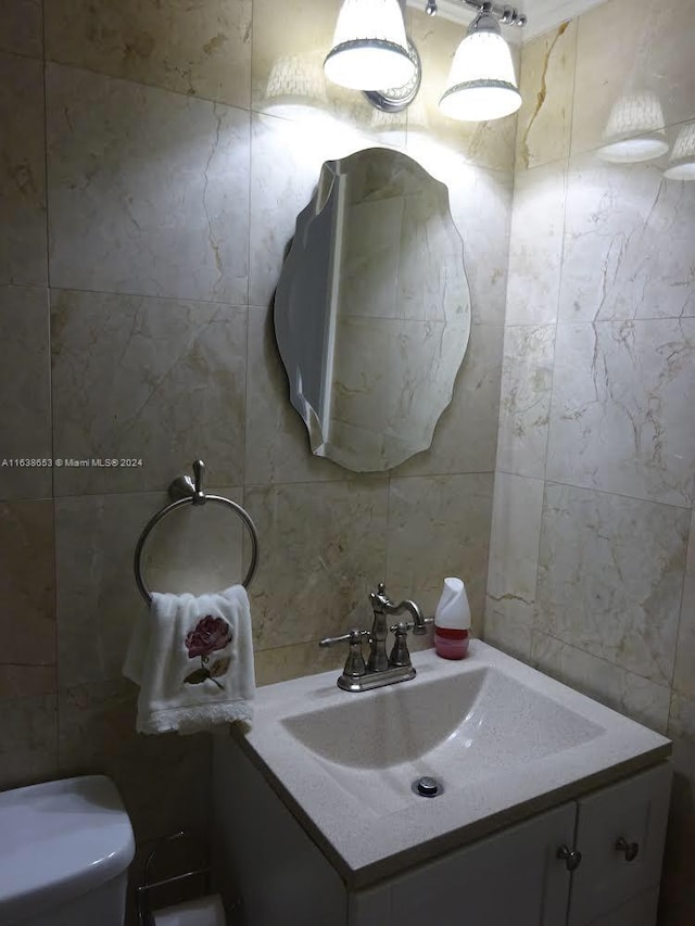 bathroom featuring tile walls, toilet, and vanity