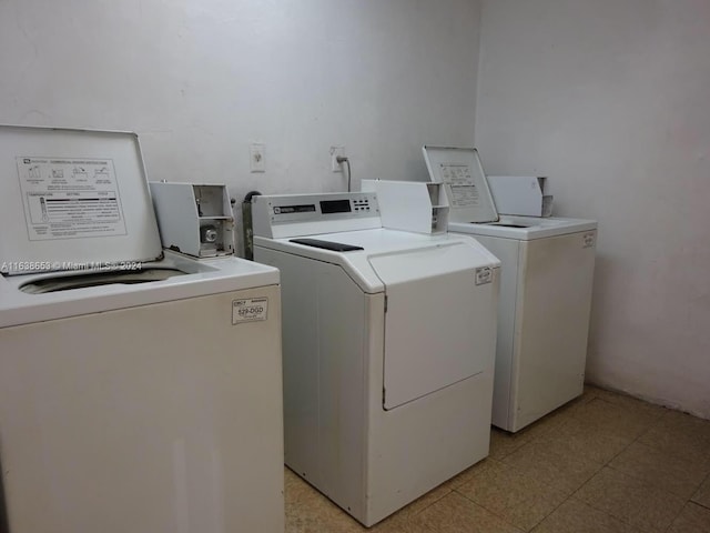 laundry room with washer and clothes dryer and light tile patterned floors