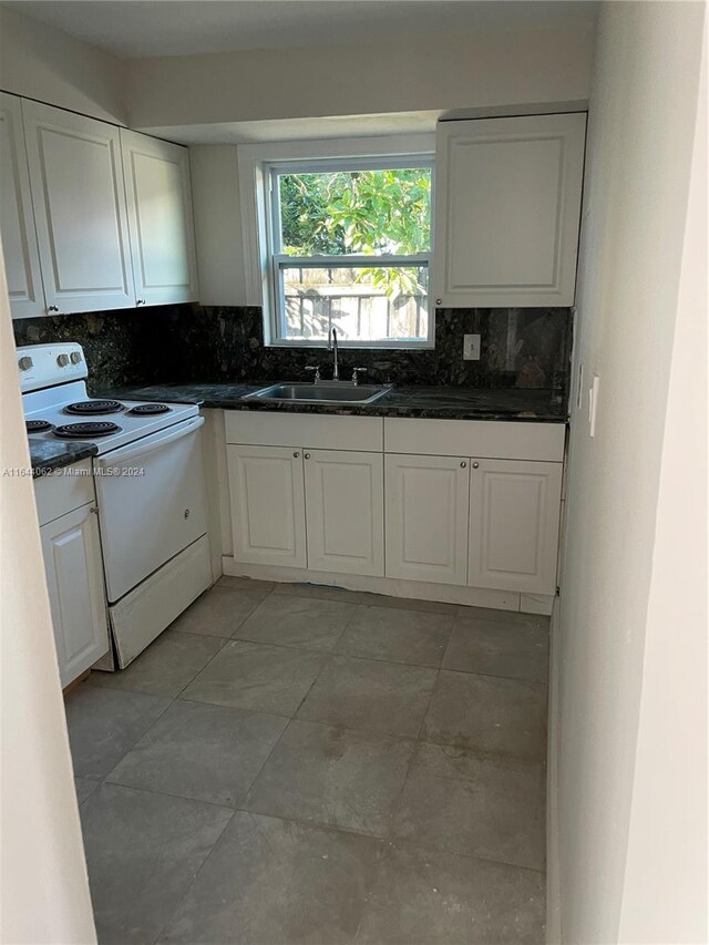 kitchen featuring white cabinets, backsplash, white electric stove, and sink