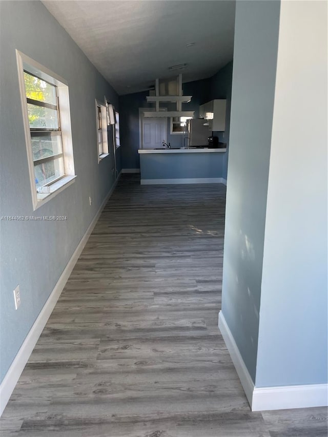 hall featuring wood-type flooring and lofted ceiling