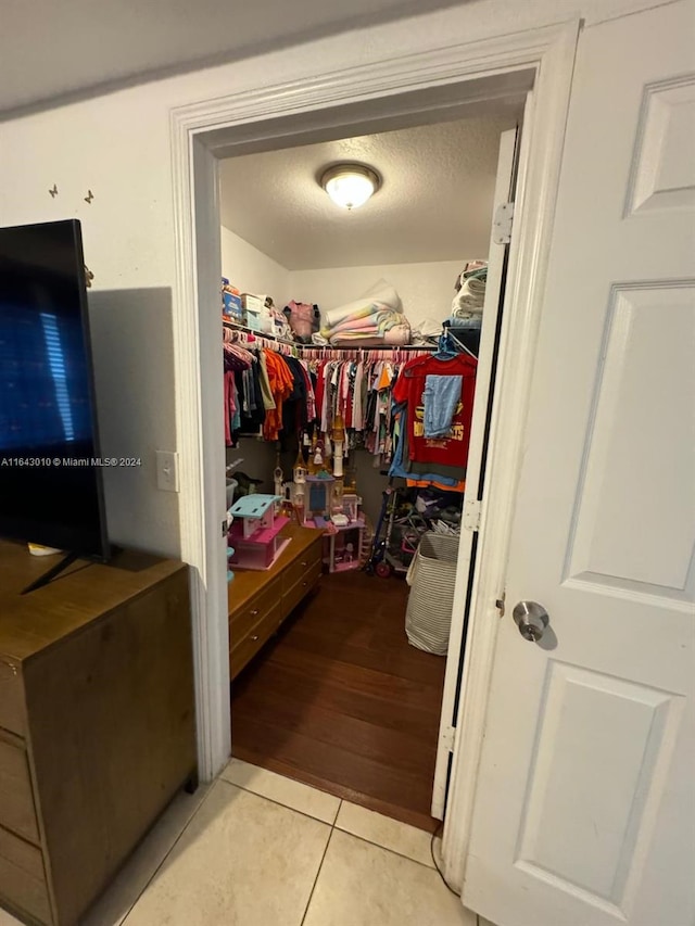 walk in closet with light tile patterned floors