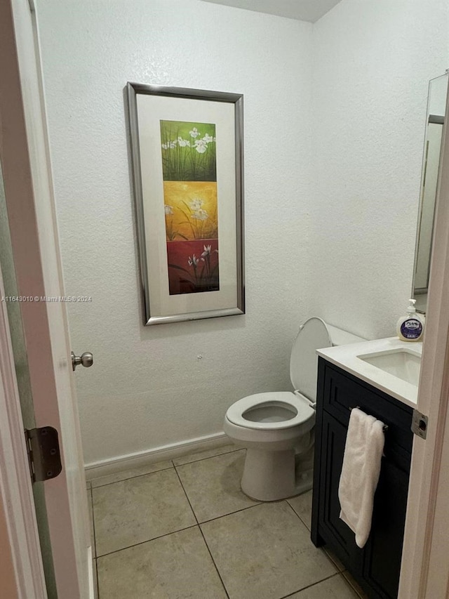 bathroom featuring tile patterned flooring, toilet, and vanity