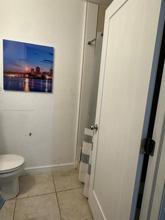 bathroom with toilet and tile patterned floors