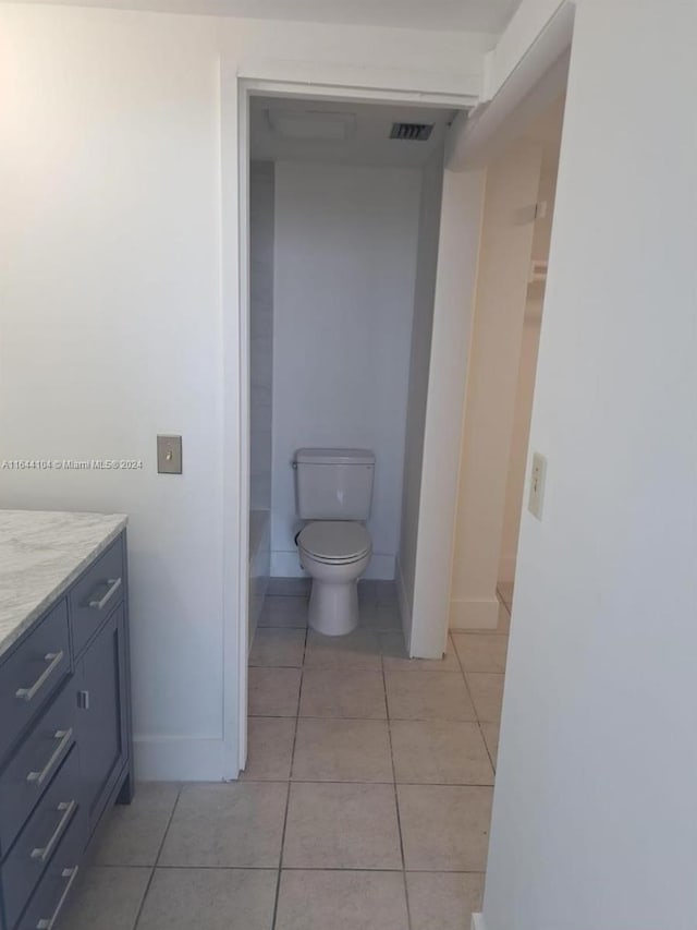 bathroom with tile patterned flooring, vanity, and toilet