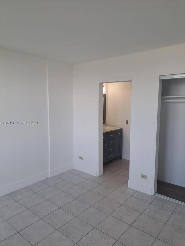 unfurnished bedroom featuring light tile patterned floors and a closet