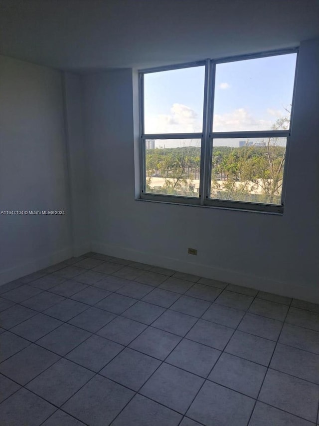 tiled empty room featuring a healthy amount of sunlight