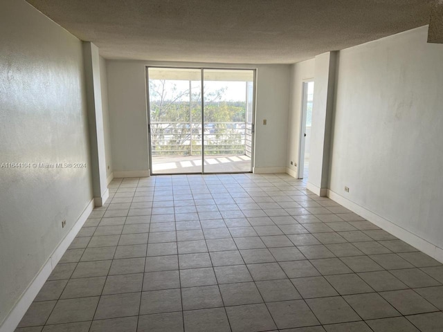 unfurnished room featuring tile patterned floors and a textured ceiling