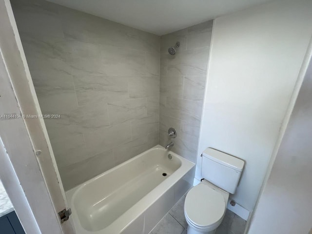 full bathroom featuring tile patterned flooring, toilet, tiled shower / bath, and vanity