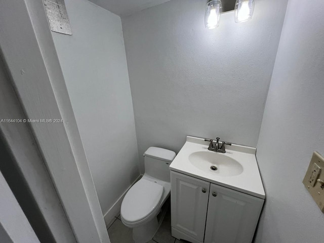 bathroom with toilet, tile patterned floors, and vanity