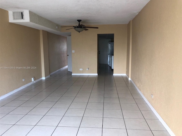 tiled empty room featuring a textured ceiling and ceiling fan