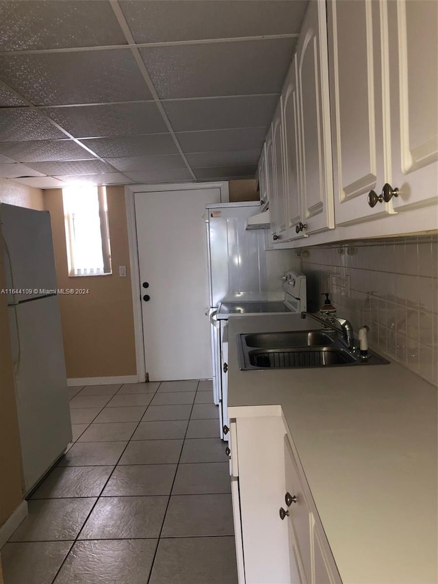 kitchen featuring backsplash, sink, range, a drop ceiling, and light tile patterned floors