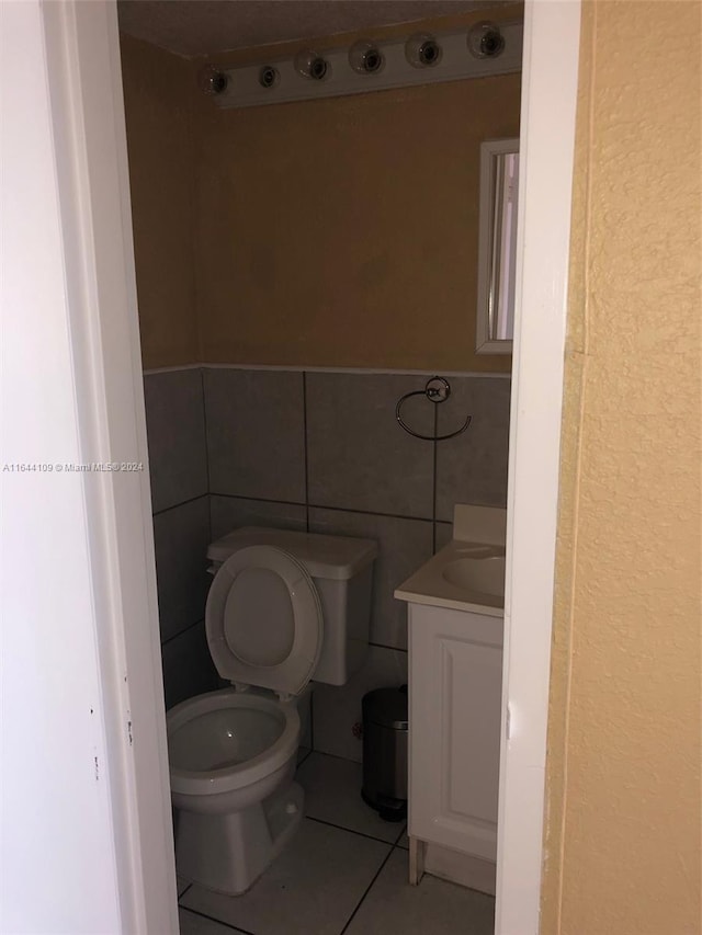 bathroom featuring tile walls, tile patterned floors, vanity, and toilet