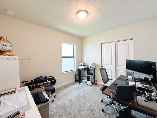 office area with a textured ceiling, carpet floors, and baseboards