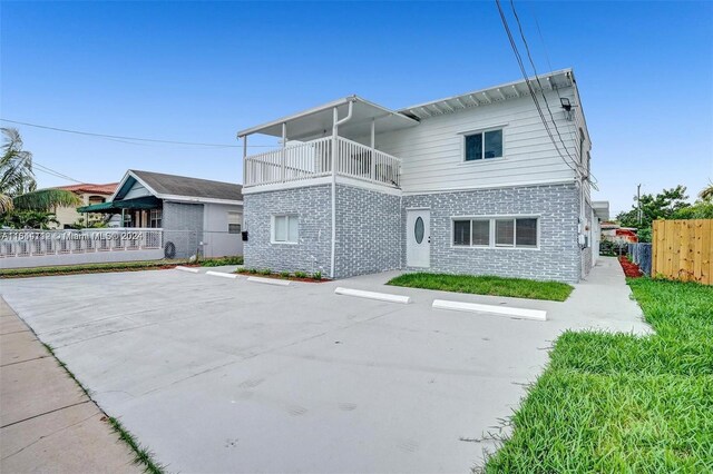 rear view of property featuring a balcony