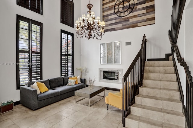 living room with a towering ceiling, light tile patterned flooring, and an inviting chandelier